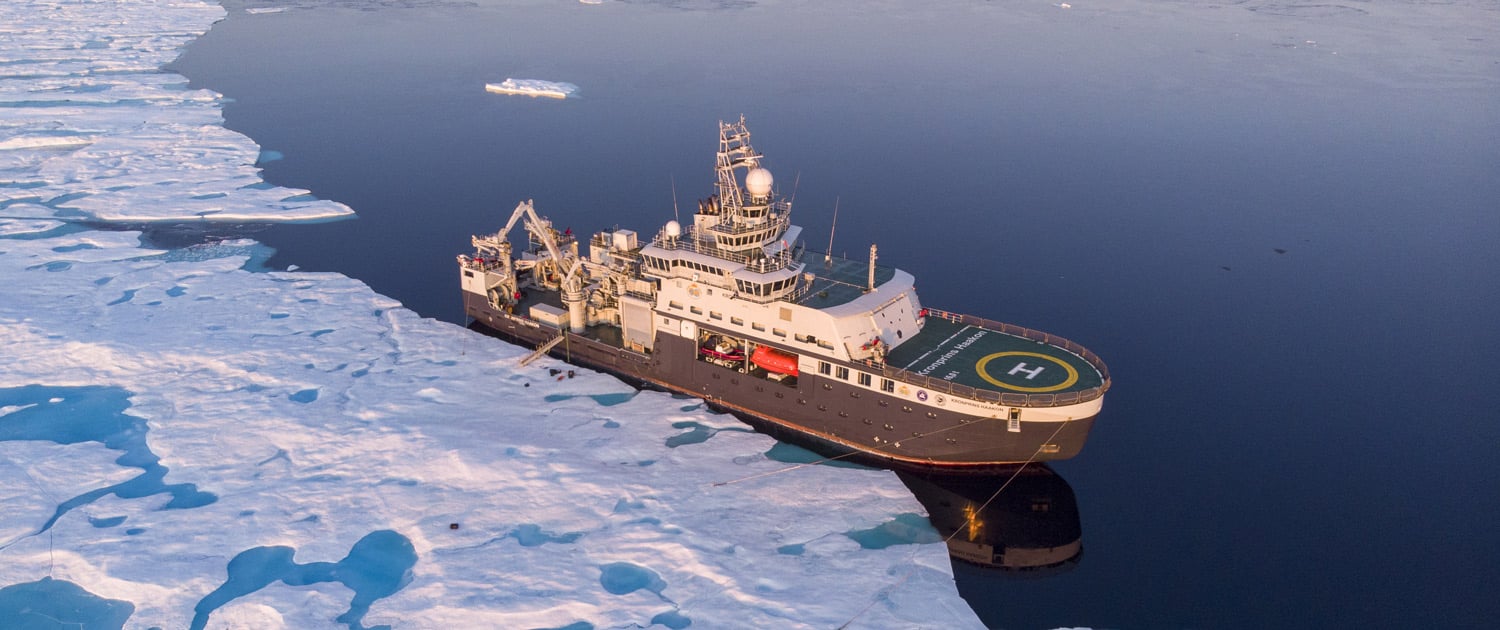 Aearial photo of ship by snow covered coastal line