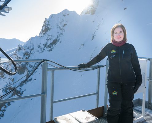Kvinne står foran snødekte fjell