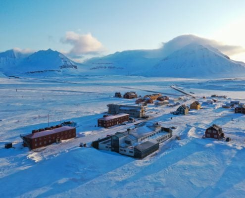 En rekke hus og fjell i bakgrunnen