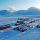 En rekke hus og fjell i bakgrunnen