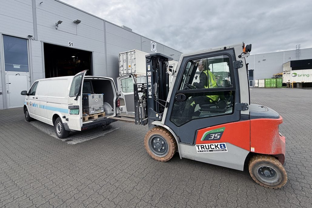 En truck laster noe inn i en bil
