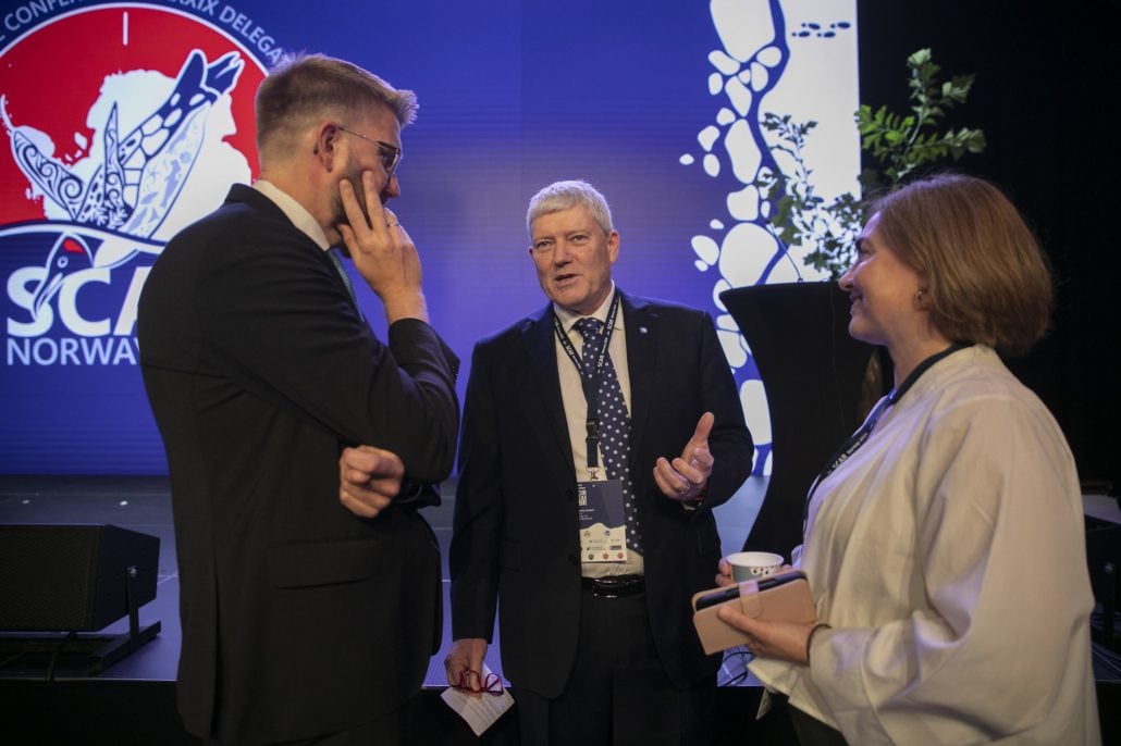 To menn og en kvinne snakker sammen