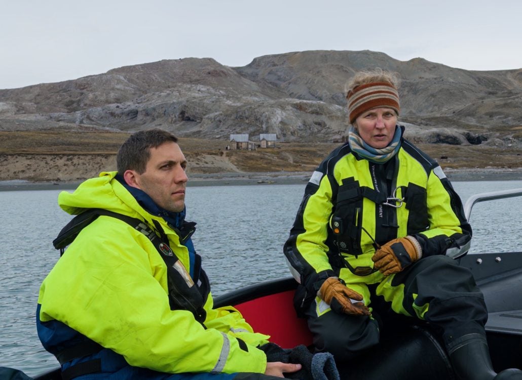To personer sitter i en båt på en fjord.